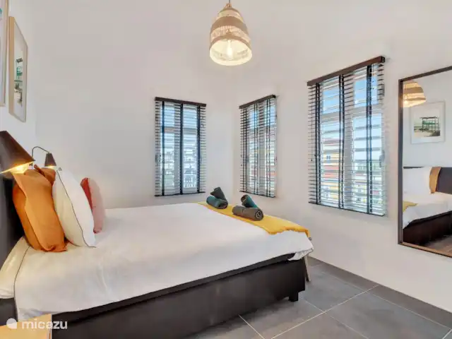 Villas sur l'Eau Appartement 3 Chambres | Bonaire, Bonaire, Kralendijk - appartement Première chambre avec lit double confortable, armoire, miroir et climatisation.