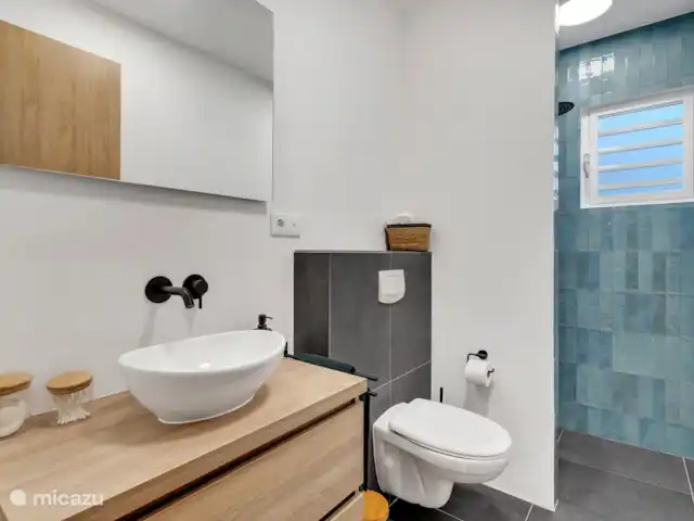 Villas sur l'Eau Appartement 3 Chambres | Bonaire, Bonaire, Kralendijk - appartement Première salle de bain avec douche pluie, WC et lavabo avec meuble pour ranger toutes vos affaires.