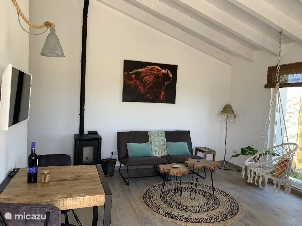 Woonkamer met uitzicht over de tuin. Een goede kachel voor de wintermaanden.