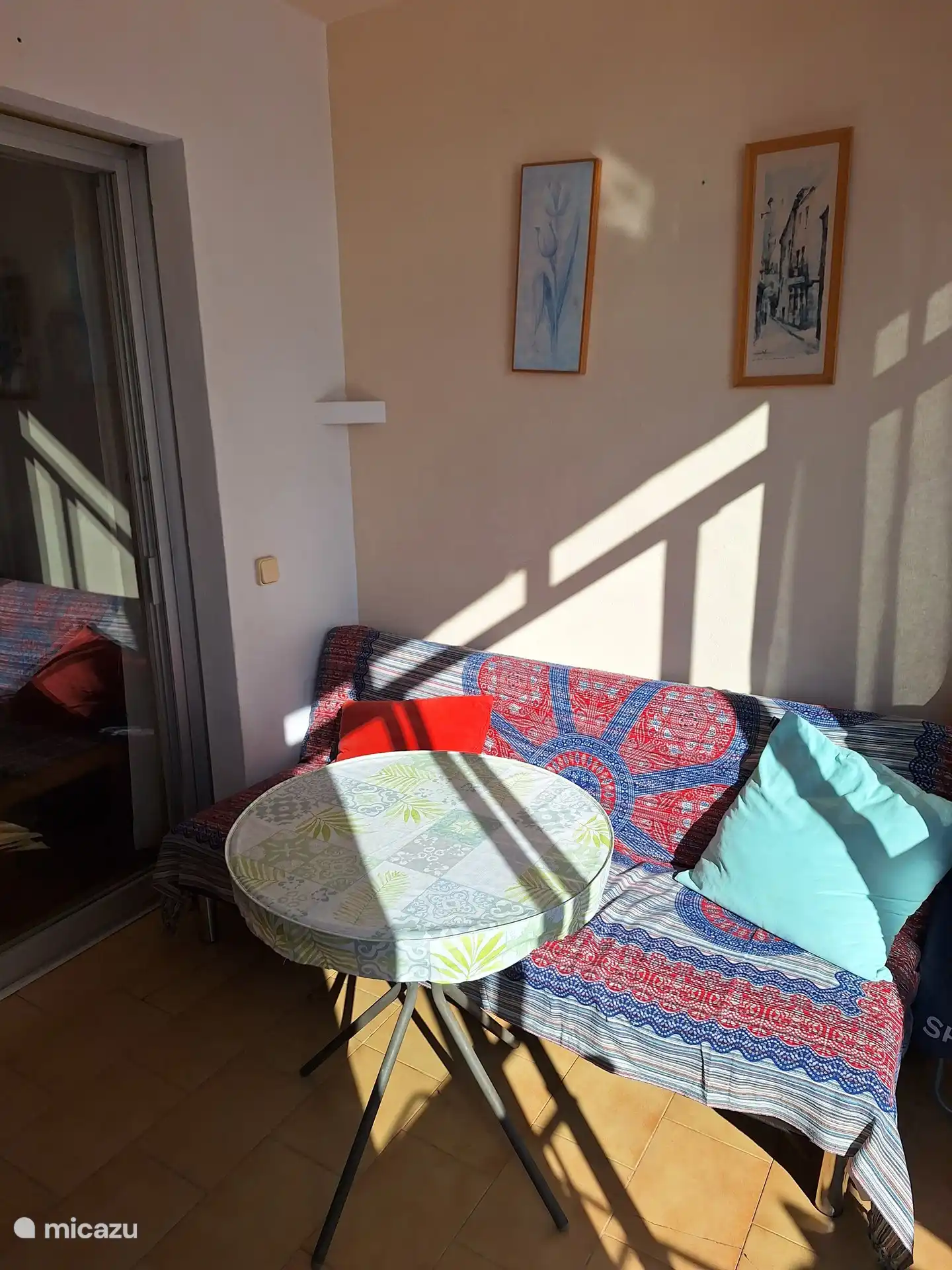 From the living room with open kitchen a view through the conservatory where the bicycles are visibly present.