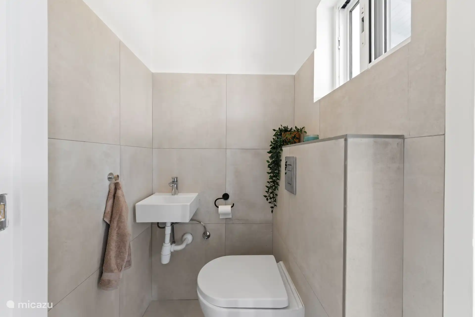 Gastentoilet, direct naast de porch om natte voeten door het huis te voorkomen.