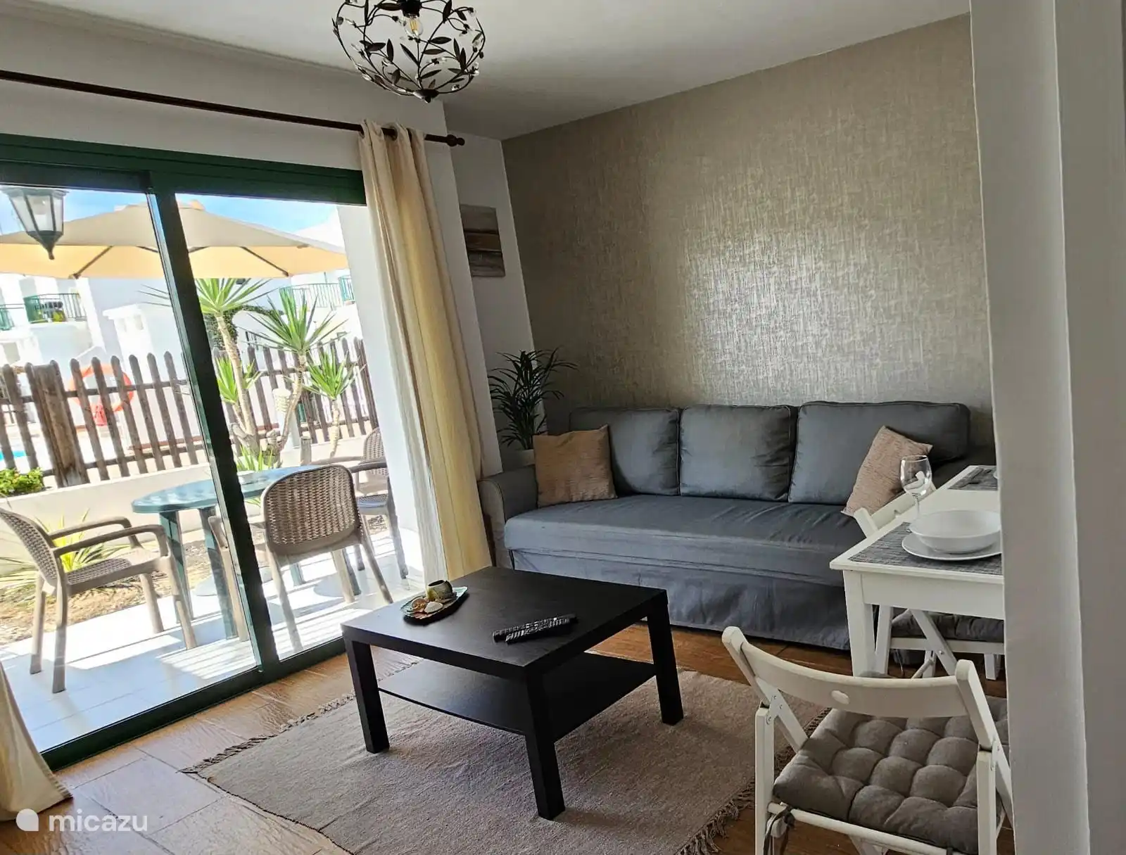 Wohnzimmer mit Schiebefenster zur Terrasse. Das Sofa kann in ein Bett für 2 Personen umgewandelt werden. 