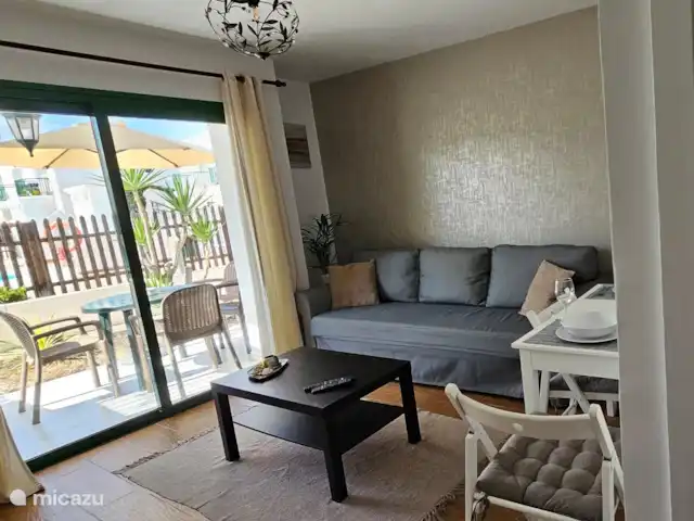 casa lisa en España, Fuerteventura, Corralejo - apartamento Salón comedor con ventana corredera a la terraza. El sofá se puede transformar en una cama para 2 personas.