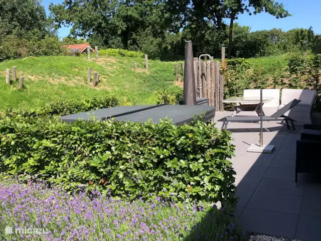 Entre les collines du vieux village | Pays-Bas, Hollande méridionale, Ouddorp - maison de vacances Vue sur la terrasse avec jacuzzi et douche extérieure où vous pourrez vous rincer après une merveilleuse journée à la plage