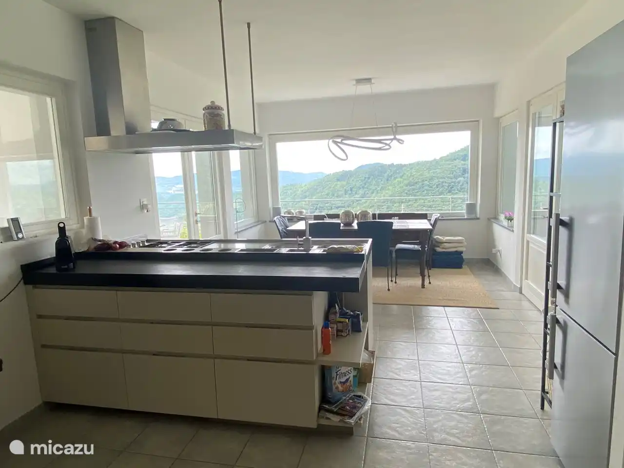 Offene Küche mit Esstisch für 8 Personen mit schöner Aussicht über die Hügel