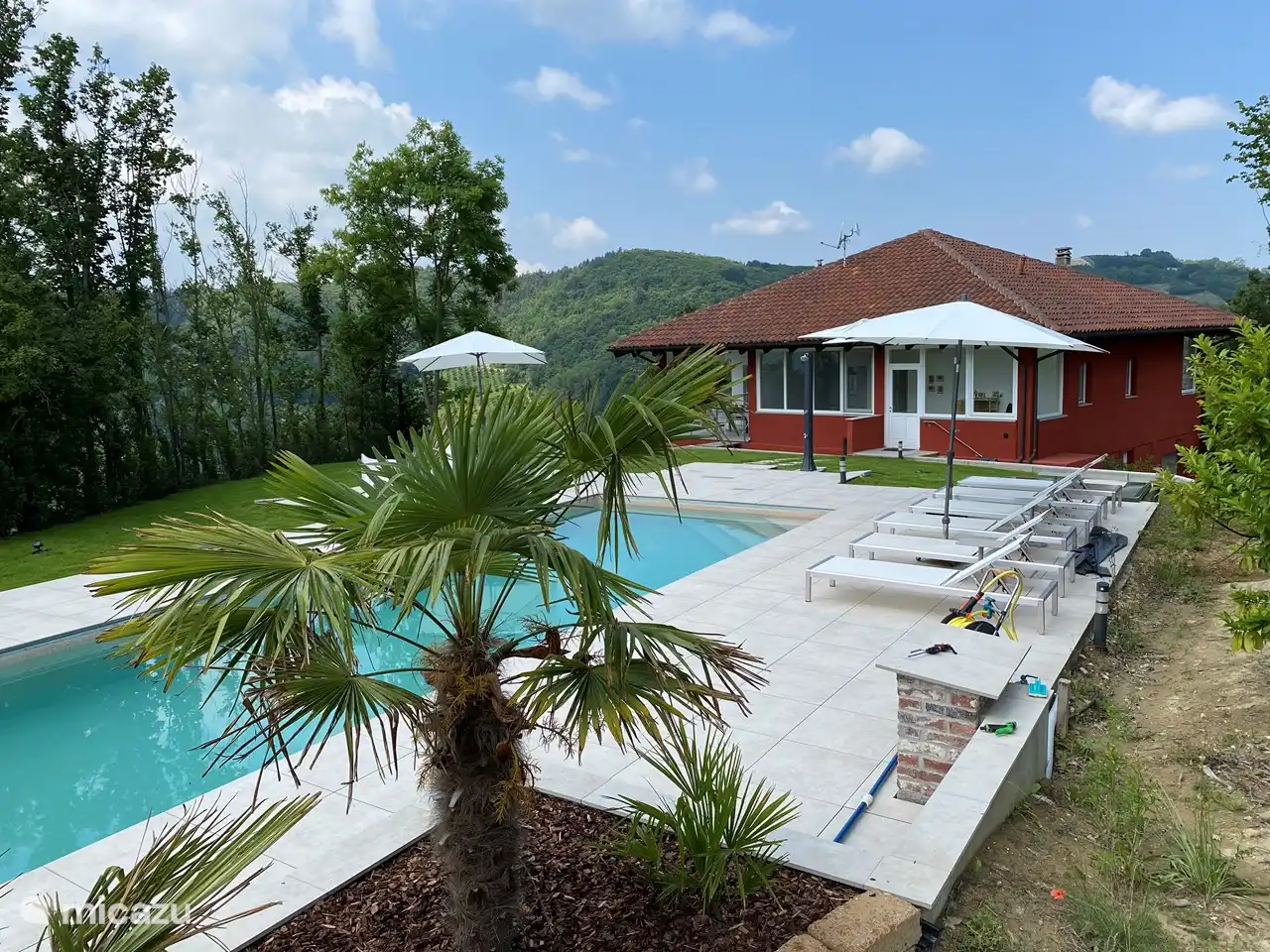 6 Sonnenliegen am Pool mit Sonnenschirmen auf einer großen Terrasse