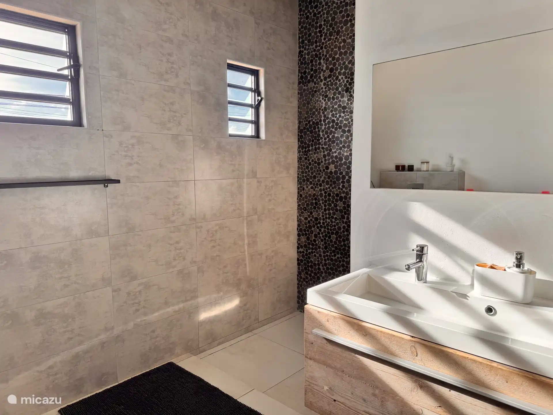 Ruime badkamer met douche en dubbele wastafel