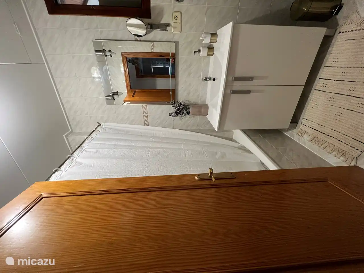 Eines der beiden Badezimmer mit Badewanne, Dusche und WC. Es gibt auch eine Waschmaschine