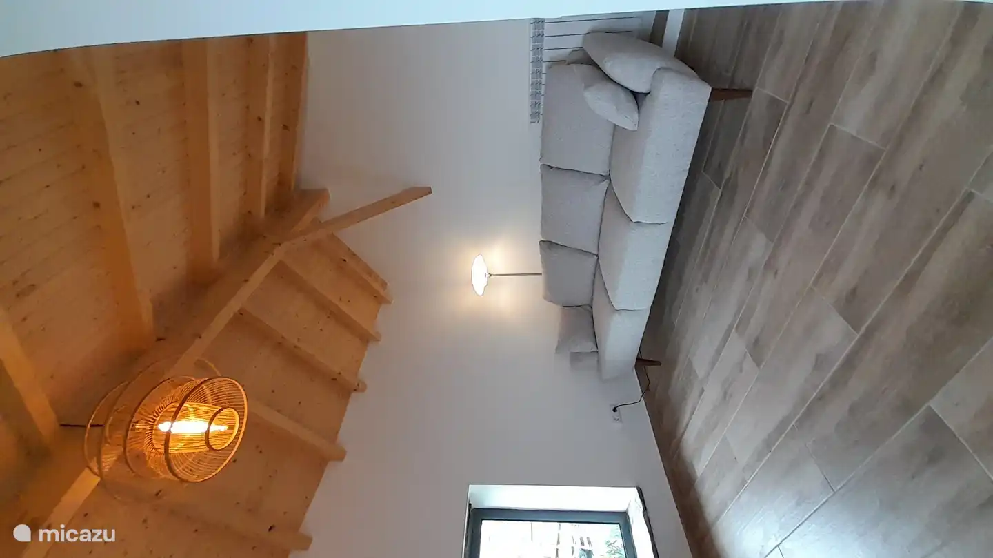 Der zweite Wohnbereich, mit einem großen Sofa, einem Fernseher und einem Schreibtisch