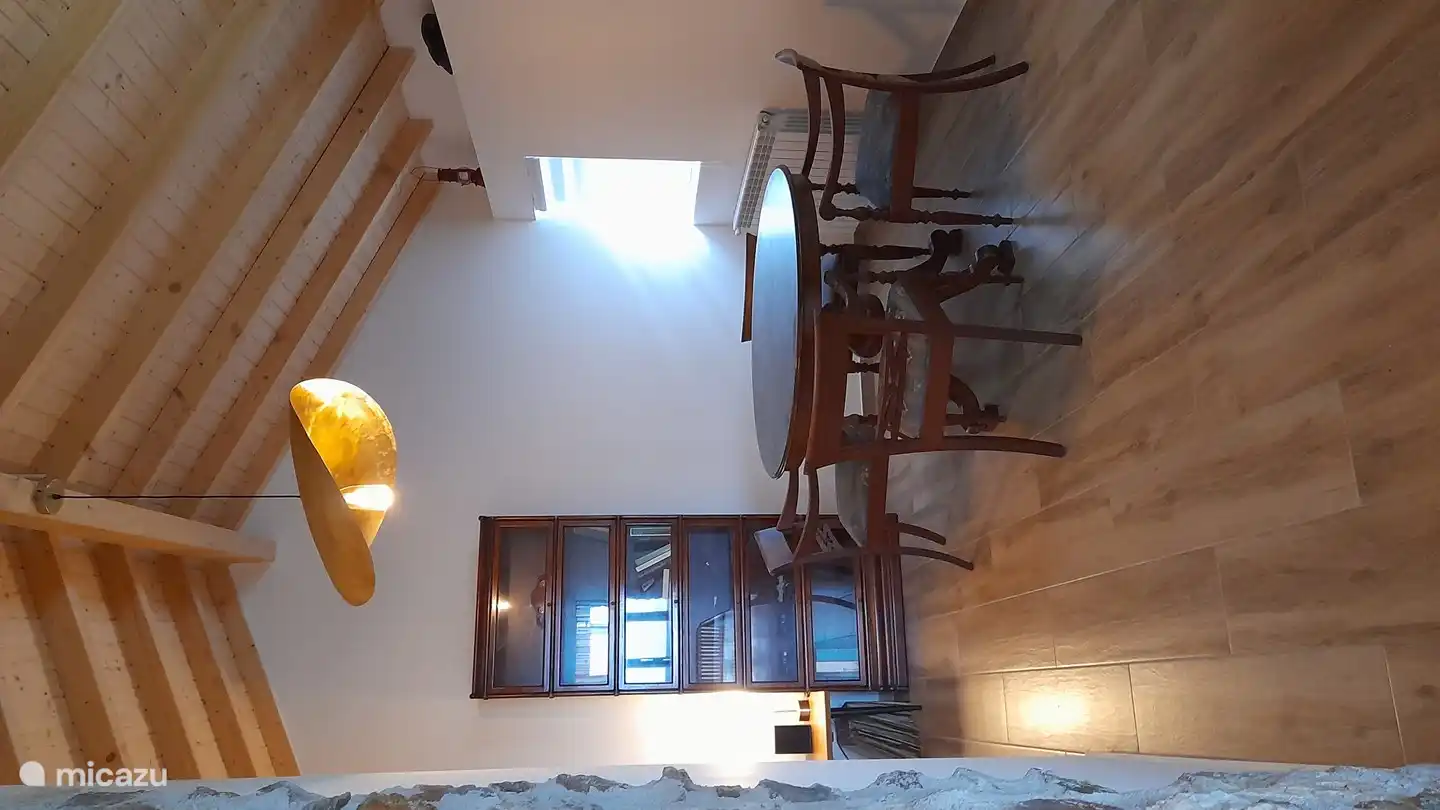 Im L-förmigen dritten Wohnzimmer finden Sie einen runden Tisch mit Stühlen, ein Bücherregal und einen Plattenspieler mit Schallplatten