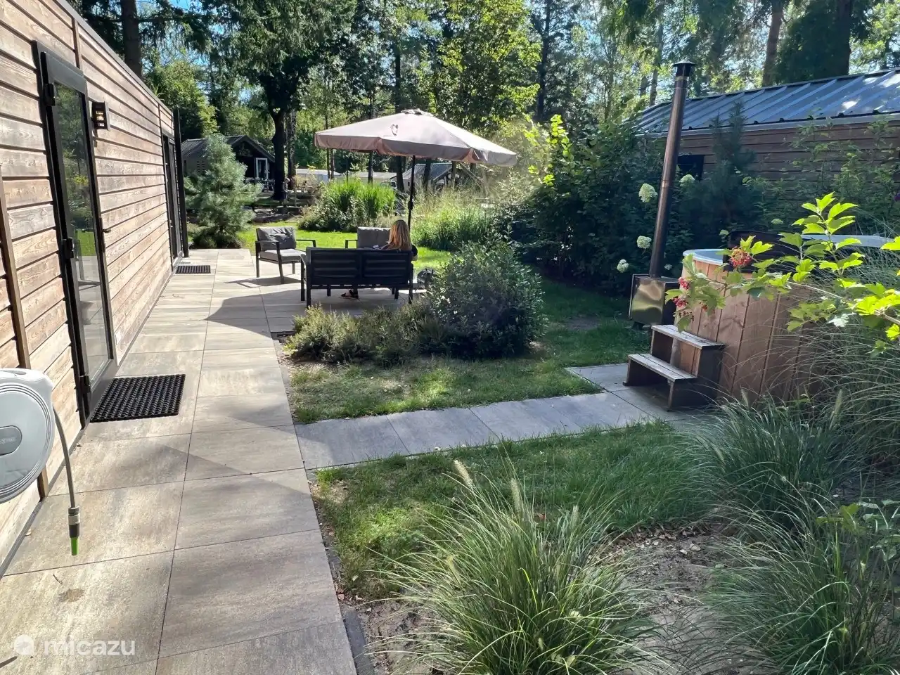 die Terrasse mit Sonnenschirm und Loungesofa