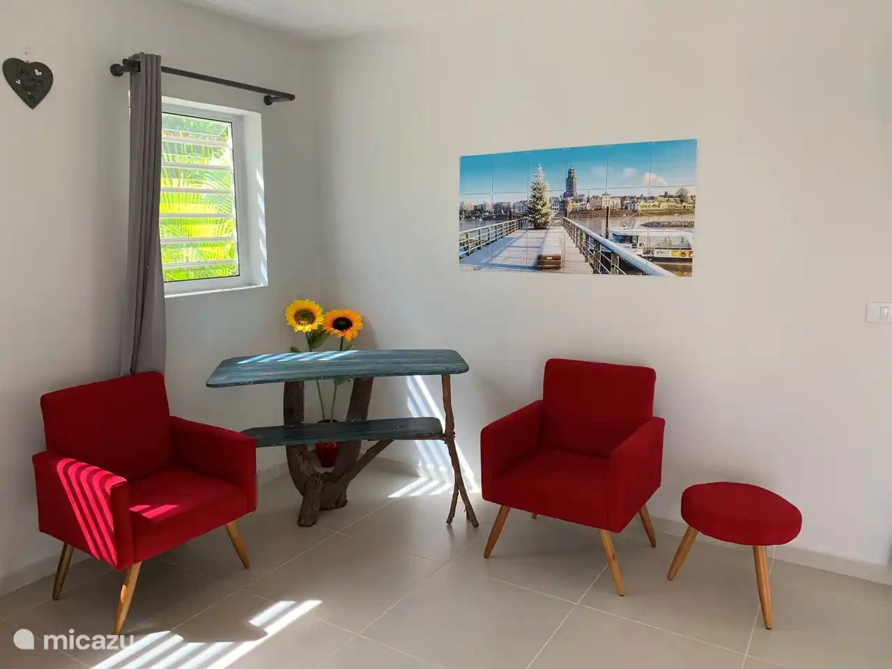 De woonkamer heeft meerdere zitjes, waarbij we veel kleur hebben gebruikt bij de inrichting. Kleur wat zo kenmerkend is voor Curaçao. De ixxi is een ontzettend mooie foto van Deventer in de sneeuw, gemaakt door Jan Haitsma.