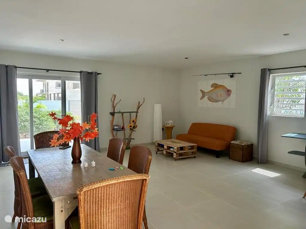 De houten 'salon' tafel is gemaakt van pallets en net als het mooie kunstwerk bij de muur zijn deze zelfgemaakt.