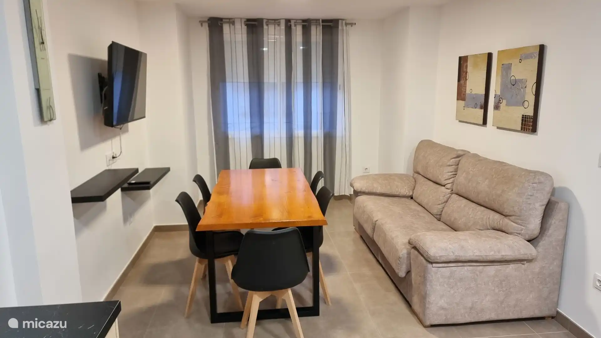 Sala de estar con tv pantalla plana ,mesa comedor para 5 personas plaza sofá para 4 personas ,zona amplia y luminosa.