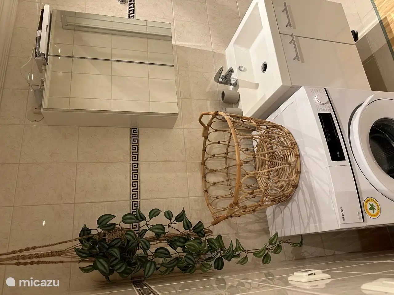 im Badezimmer ist eine nagelneue Waschmaschine mit einem Wäscheständer daneben