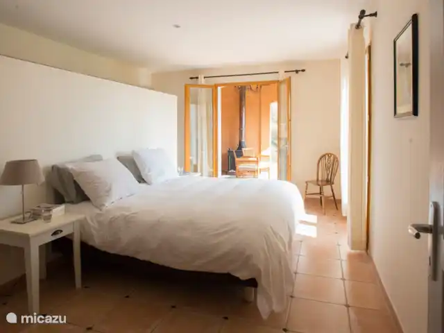 Tréville | France, Hérault, Saint-Chinian - villa Chambre des maîtres avec portes-fenêtres donnant sur le jardin et la terrasse couverte. Salle de bain et toilettes attenantes.