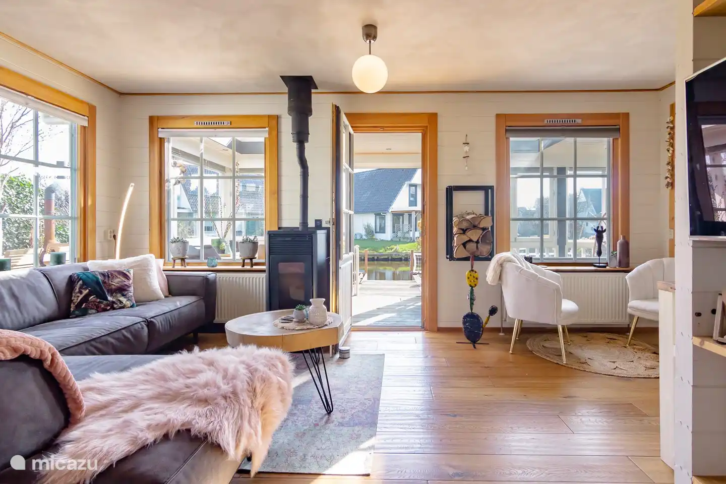 L'espace de vie jouxte la cuisine ouverte avec un joli poêle à granulés et un accès à la véranda et au jardin sur l'eau.