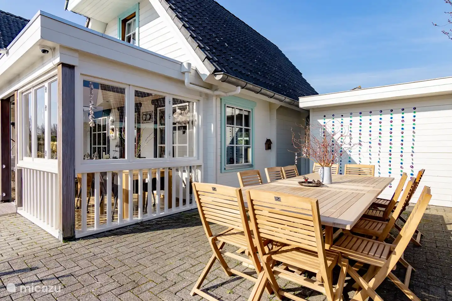 La table de jardin avec des chaises à côté de la véranda sur l'eau.