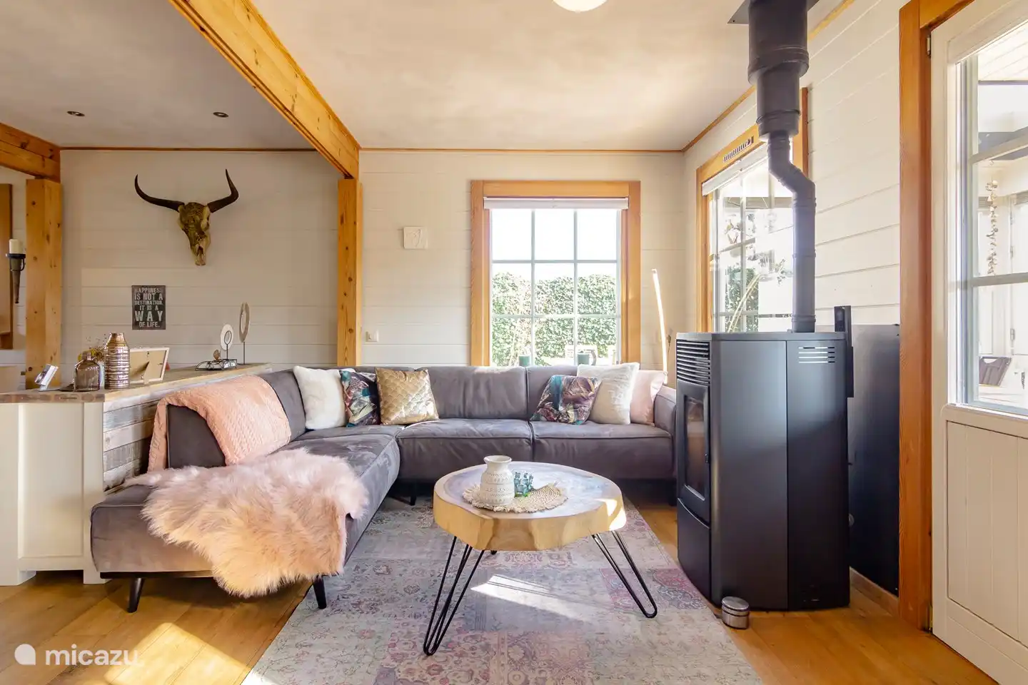 Ce salon est adjacent à la cuisine ouverte, continue dans un coin salon supplémentaire et donne accès à la véranda.