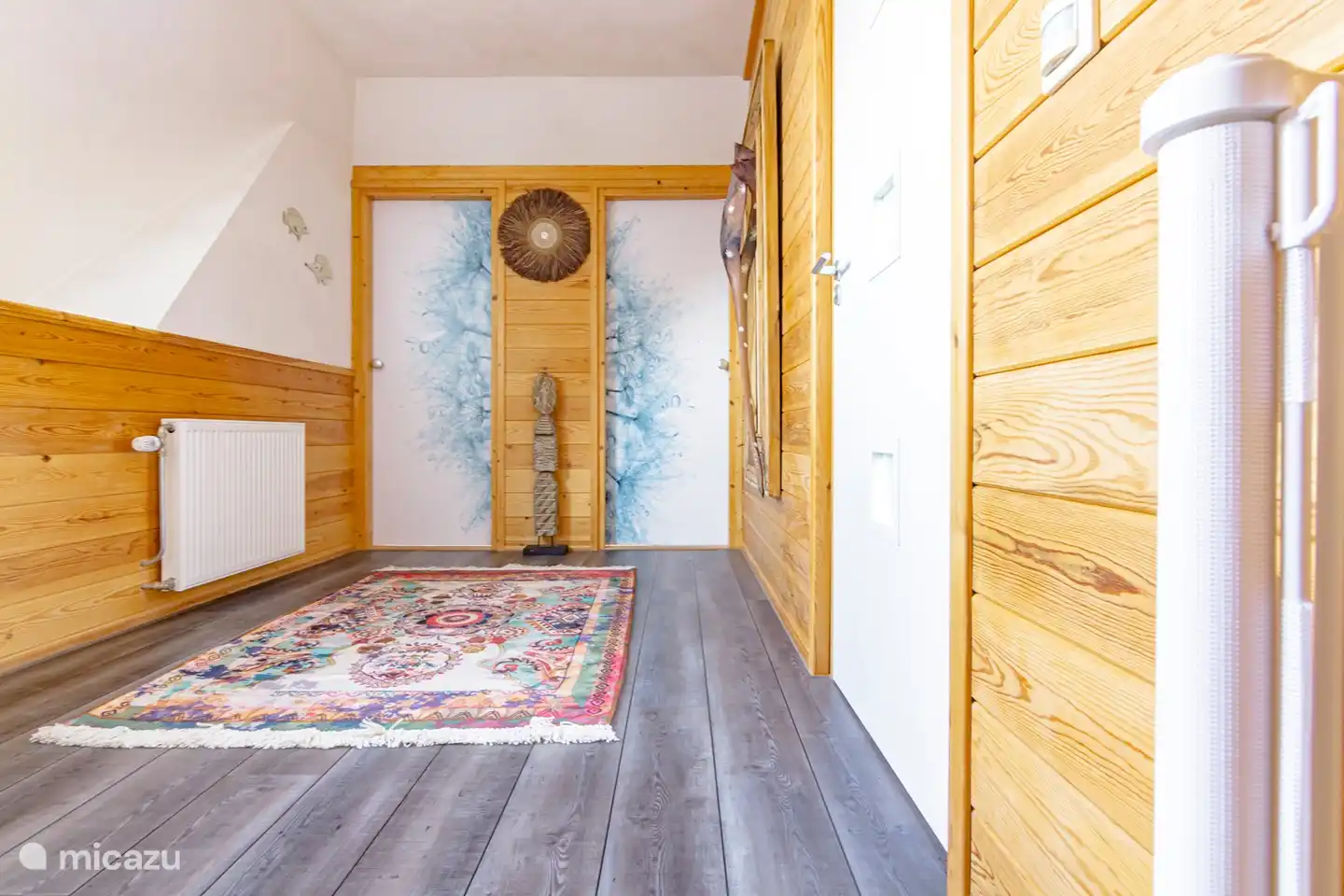 Le palier au premier étage où s'ouvrent quatre chambres et la salle de bain. Il y a une porte d'escalier.