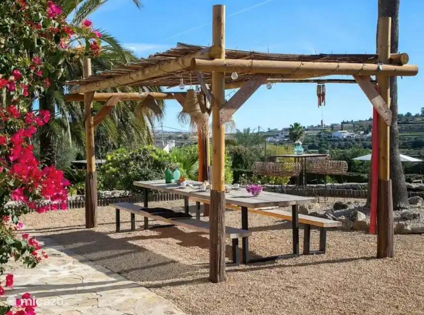 Het overdekte terras, onze overkapping met grote leestafel en banken 