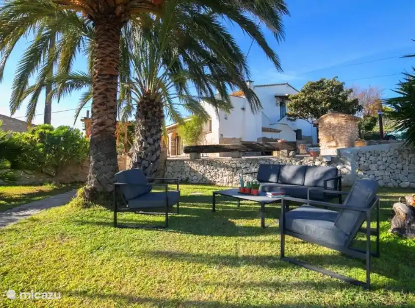 Tuin met lounge set onder de Palm bomen