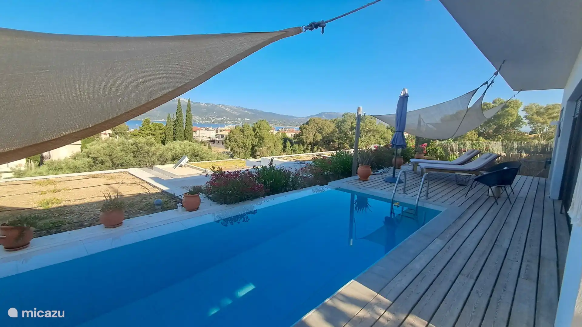 Poolbereich, schattiger Blick auf das Ionische Meer und die Berge, rechts Pogonia, links sieht man die Rückseite der Insel Lefkas
