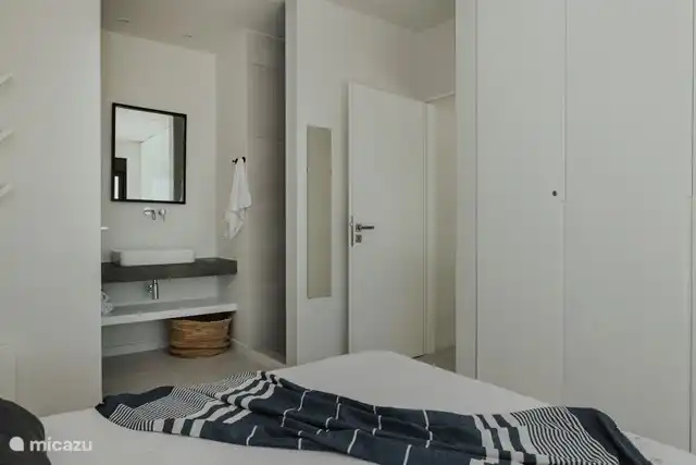 Dormitorio principal con lavabo y ducha