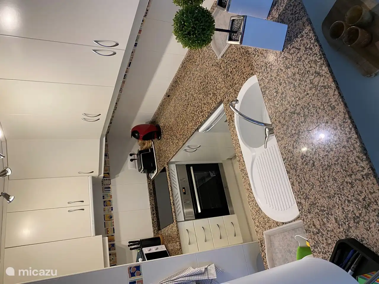 The kitchen with: induction hob microwave toaster dolce gusto, senseo and classic coffee maker. glasses, crockery and cutlery. pots and pans. kettle. kitchen towels washing machine