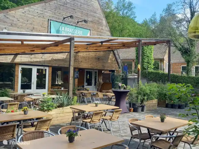 Location de Vacances Belgique, Ardennes, Durbuy, maison de vacances - Maison Tronchiennes La brasserie dans le parc avec terrasse extérieure confortable et musique live le samedi soir (juillet et août). À droite de la brasserie se trouve la piscine intérieure qui n’est accessible qu’aux clients.