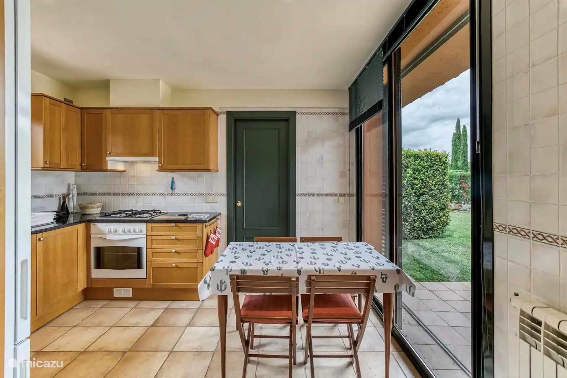 Küche mit direktem Zugang zum Garten mit großer Terrasse mit Esstisch