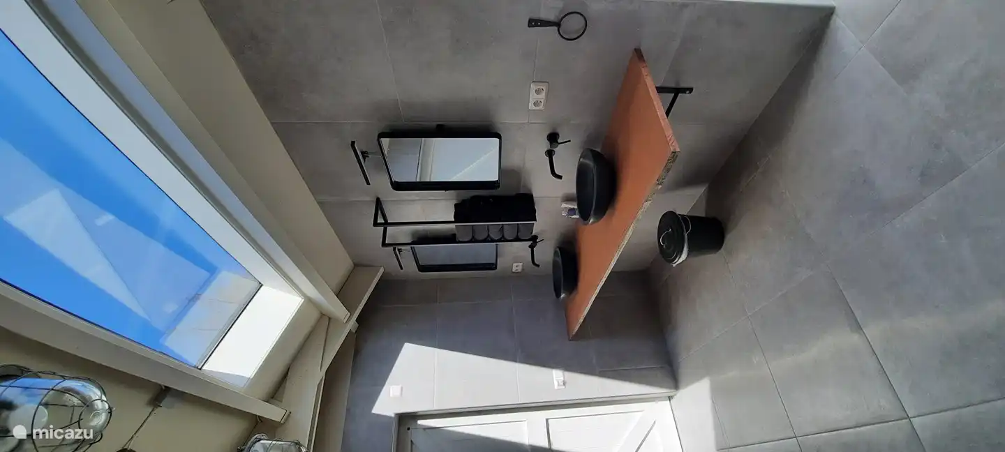 Badezimmer mit Duschstuhl, Toilettenhalterung, Kippspiegel.