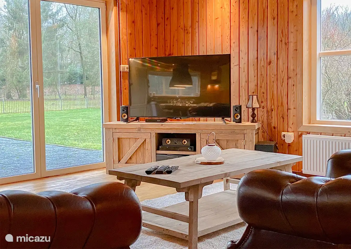 TV-Ecke mit Chesterfield-Sofas, DVD-Surround-Set und Terrassenblick.