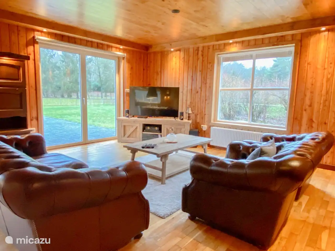 TV-Ecke mit Chesterfield-Sofas, DVD-Surround-Set und Terrassenblick.