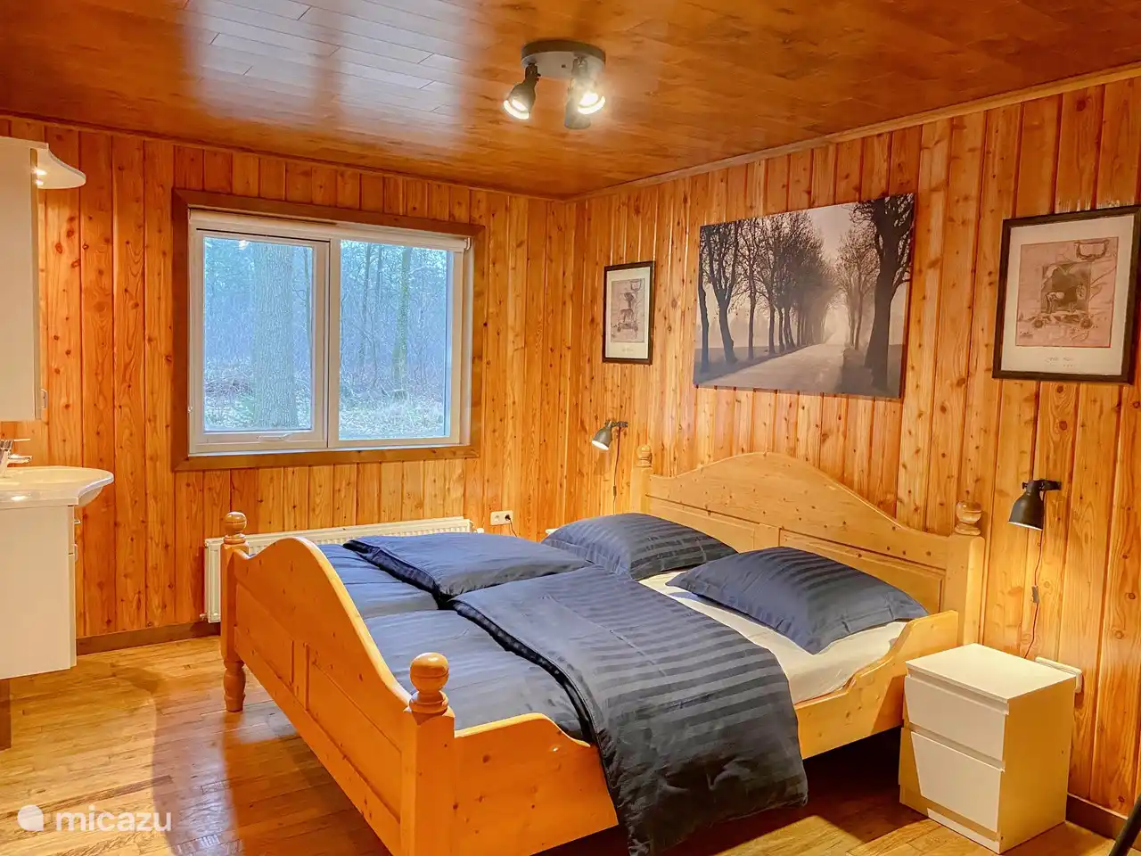 Schlafzimmer im Erdgeschoss – mit Doppelbett und privatem Waschbecken mit Spiegel und Schränken.