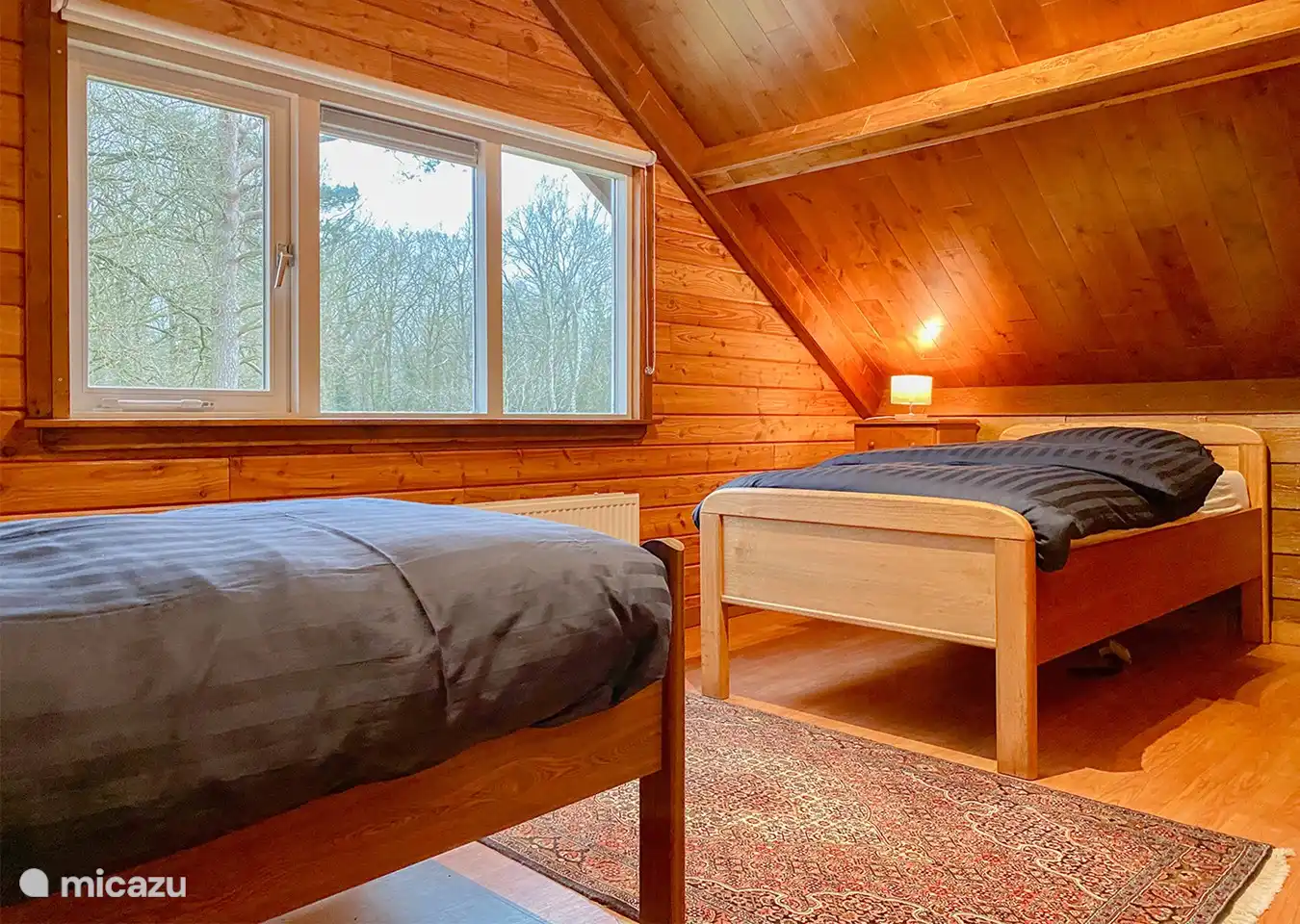 Schlafzimmer im Erdgeschoss mit zwei separaten Betten, beide mit verstellbarem Lattenunterteil und privatem Waschbecken mit Spiegel und Schränken.