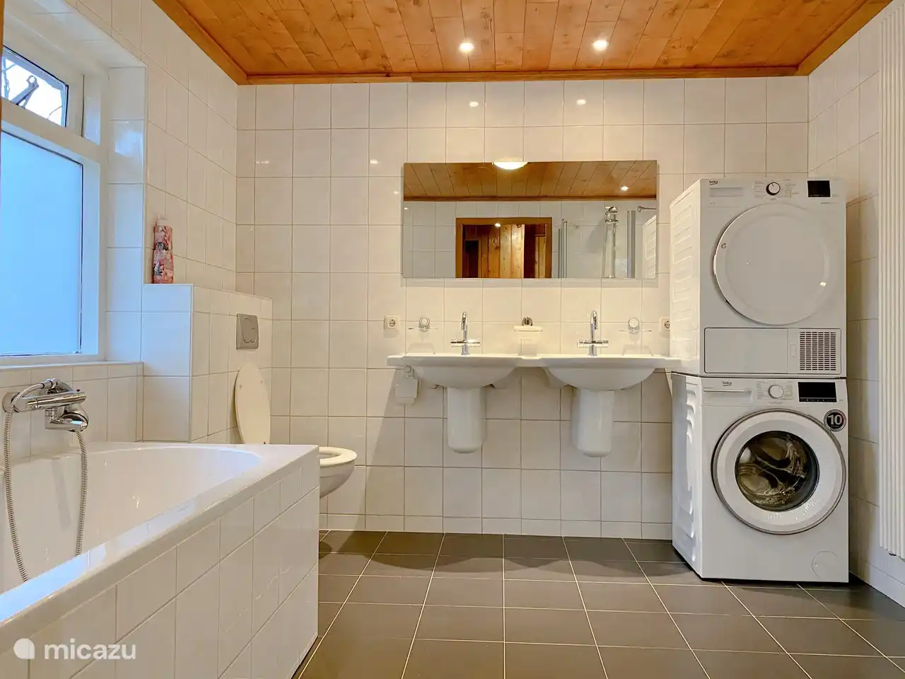 Geräumiges Luxusbad mit Bad, Toilette, Doppelwaschbecken, Wäschetrockner, Waschmaschine und Duschkabine