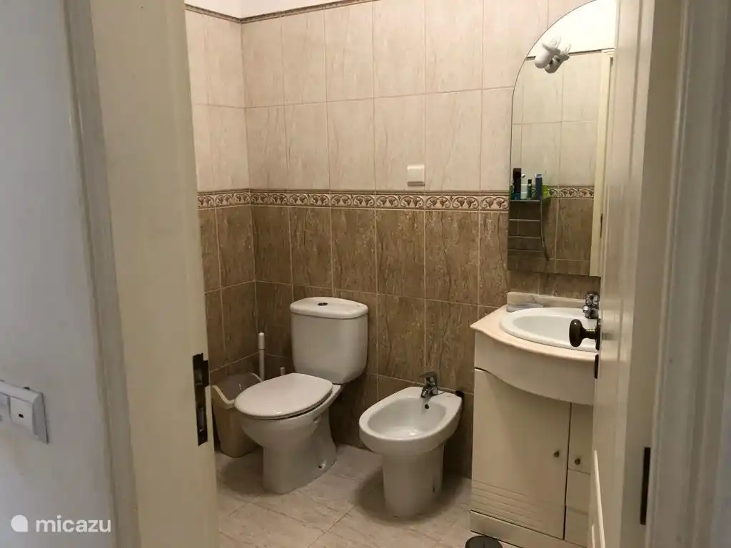 Salle de bain soignée avec WC, bidet, douche et lavabo.