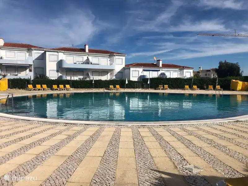 La grande et spacieuse piscine avec des chaises longues et des parasols confortables pour une merveilleuse journée à la piscine.