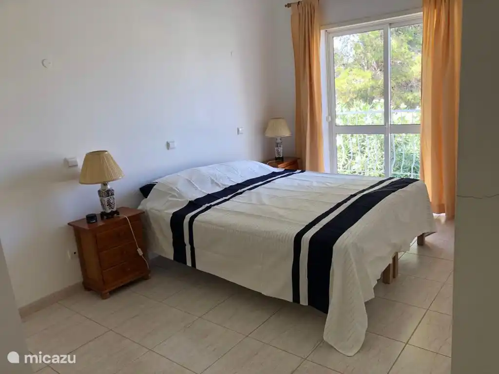 La chambre 1 est une chambre spacieuse avec un placard, un lit double, des tables de chevet et un balcon.