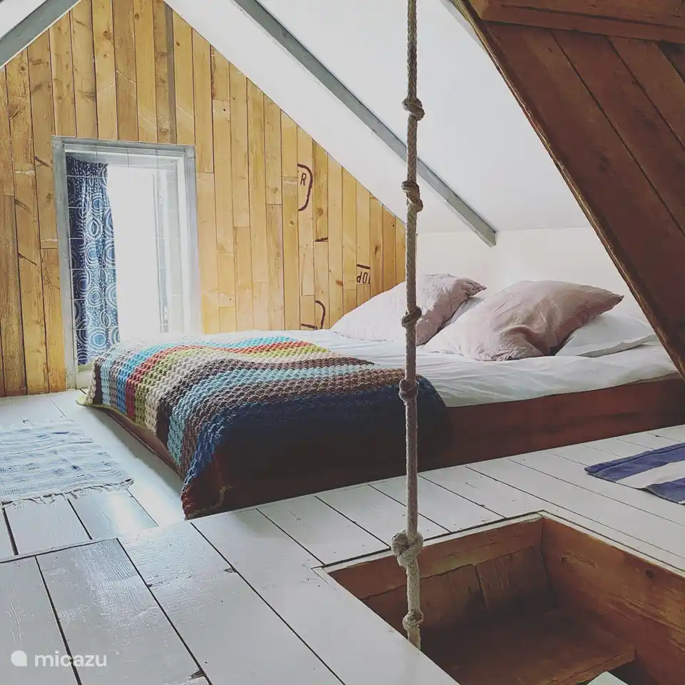 Large sleeping loft with a double bed and an extra 1 person sleeping place.