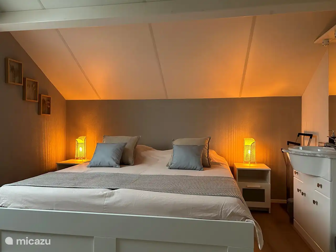 Una cama doble extra grande con lavabo, mosquiteros y ventilador para un sueño reparador.