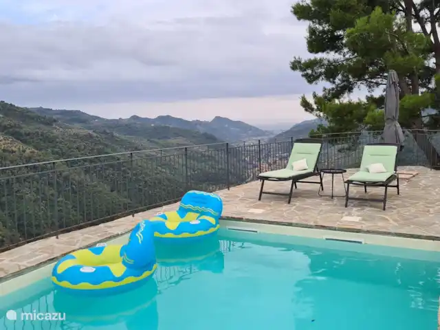 Villa Torba en Italia, Liguria, Dolceacqua - villa Siéntese en el área de la piscina privada donde puede leer, dormir o tomar un cóctel.