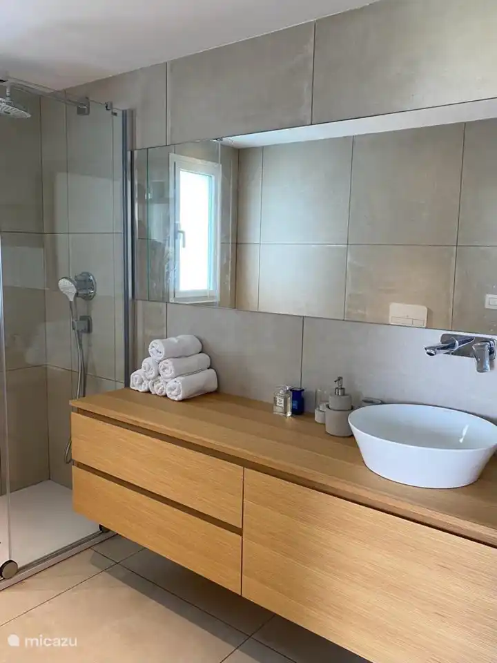 bathroom with walk-in shower, sink and toilet