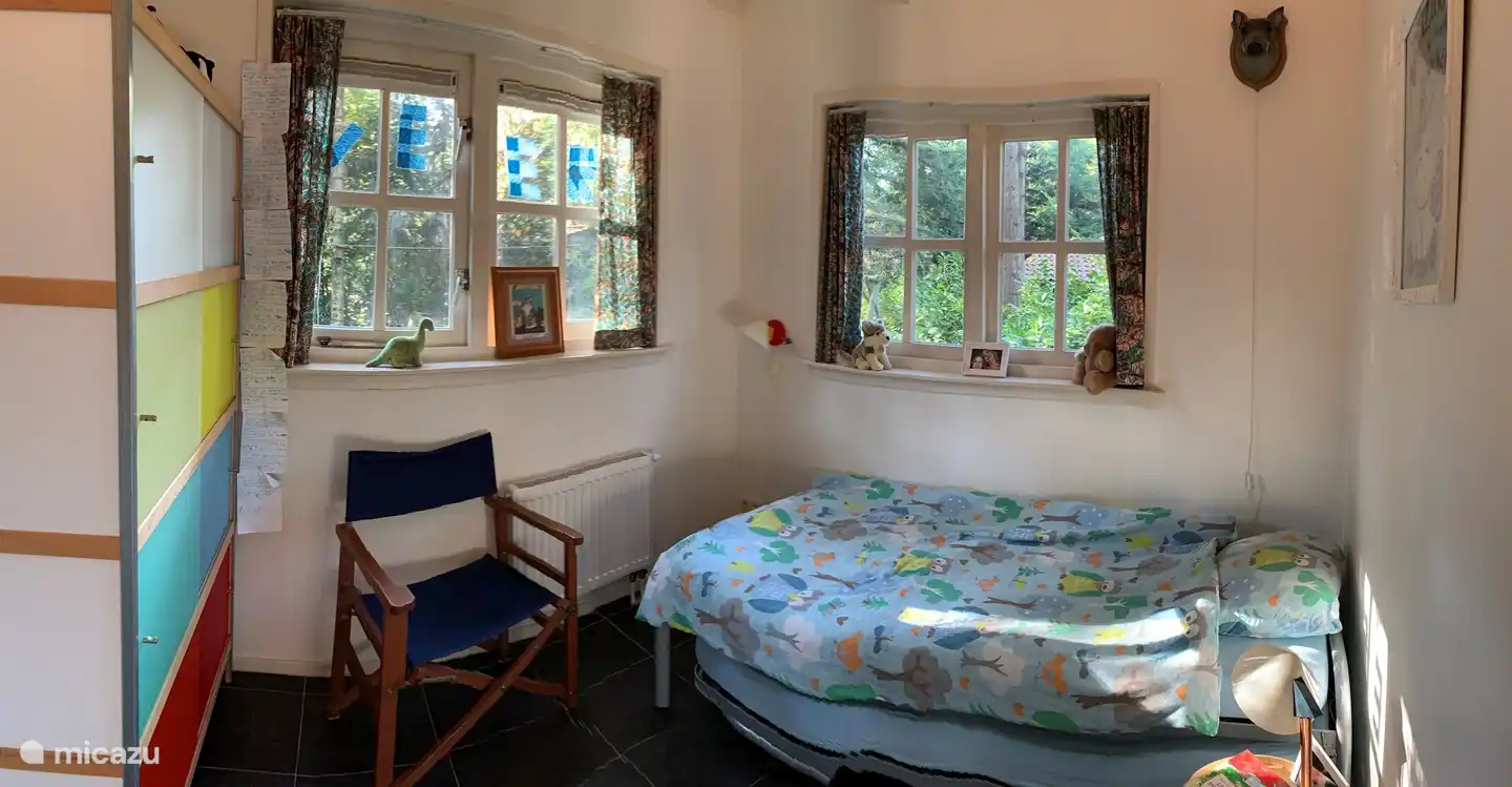 Schlafzimmer mit Einzelbett und hoher Decke