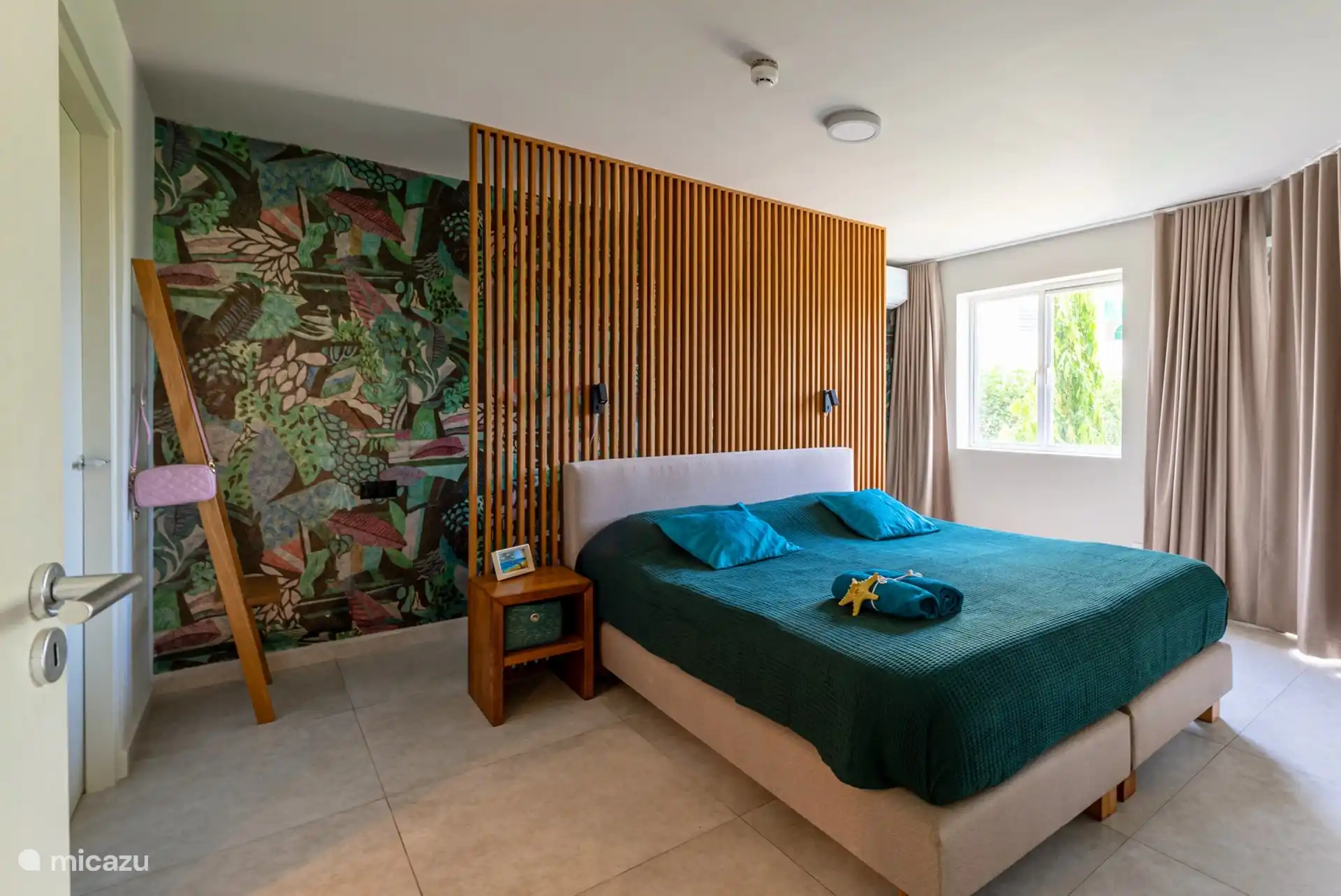 Dans la chambre se trouve la deuxième télévision et (derrière le lit) la climatisation.