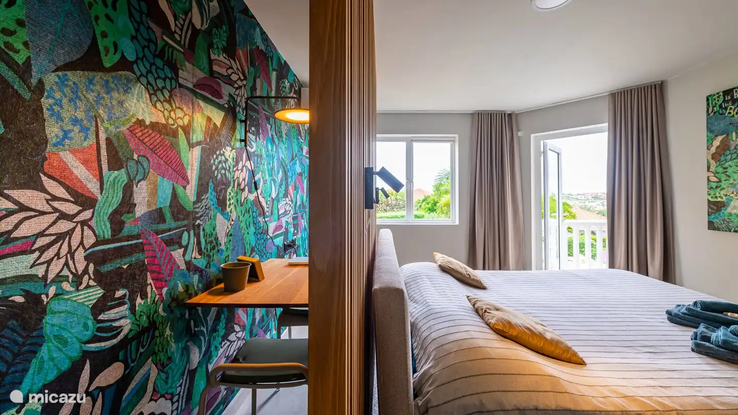 Le lieu de travail derrière le lit. L'atmosphère tropicale se reflète également ici.