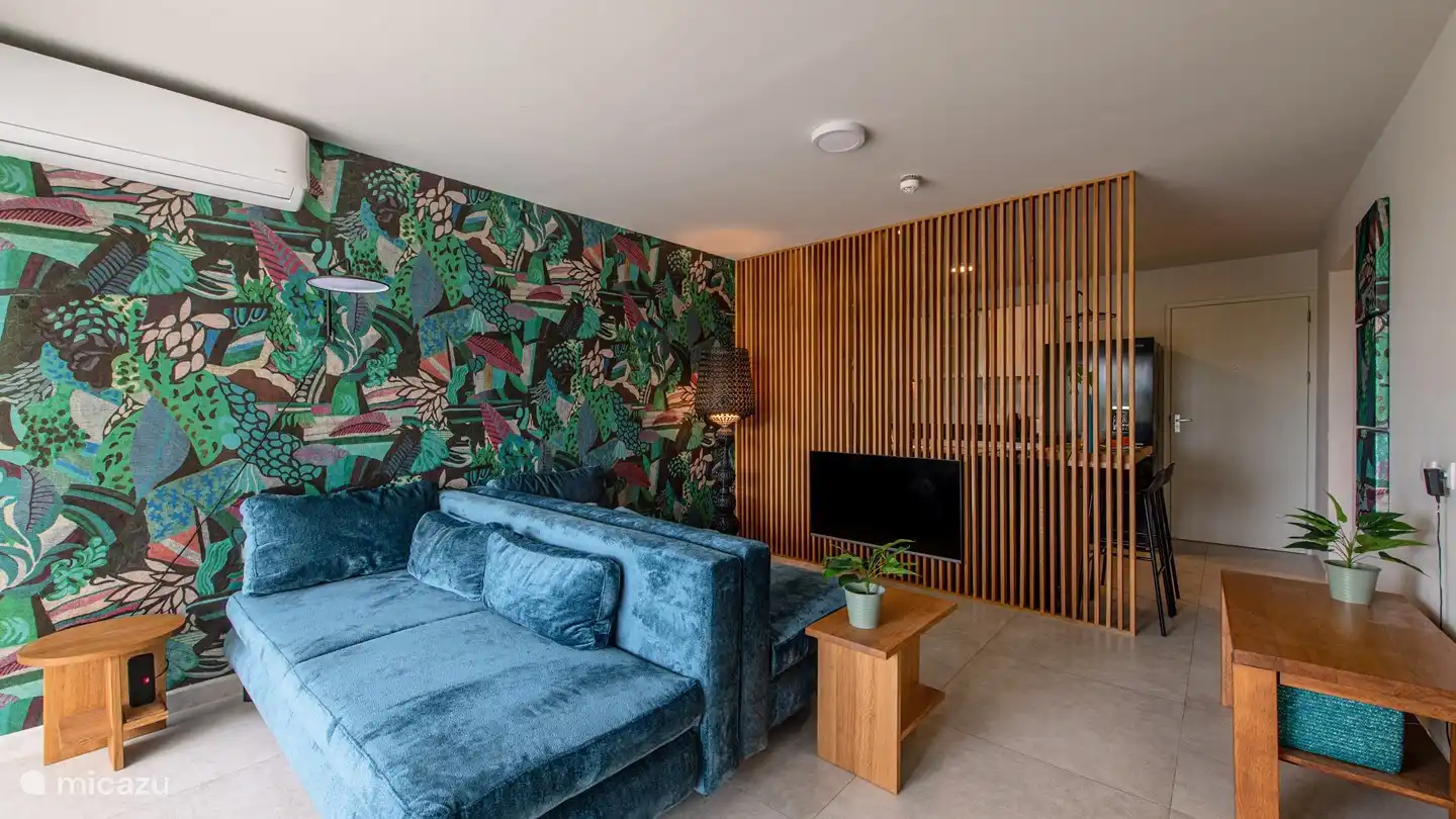 Vue d'ensemble du séjour avec la porte d'entrée à droite.