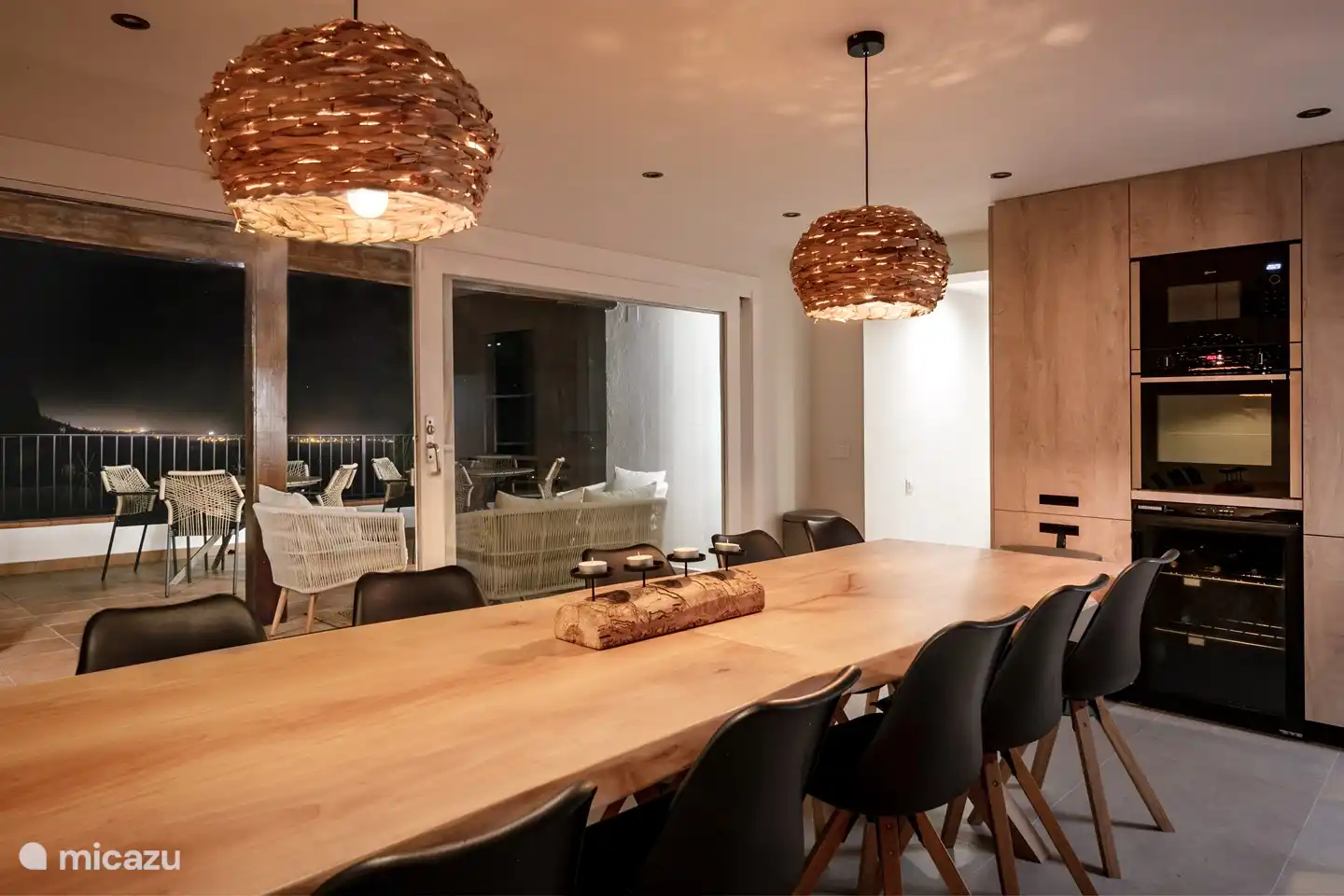 Cuisine cosy avec une belle vue sur le village illuminé le soir.