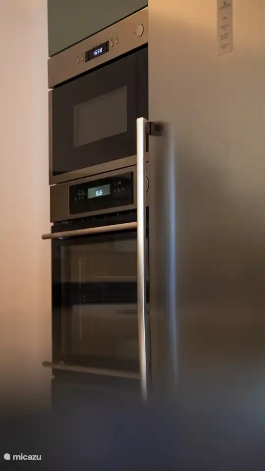 Cocina de lujo con nevera grande, horno y microondas.